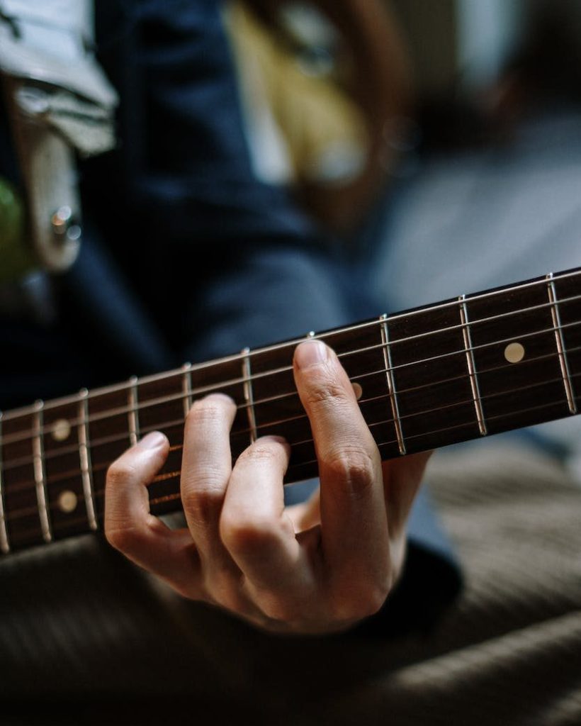 person playing guitar in black shirt
